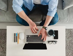 Image d'un freelance travaillant sur un ordinateur portable dans un environnement flexible (par exemple, un espace de coworking ou à domicile) pour représenter la flexibilité dans l'environnement de travail.